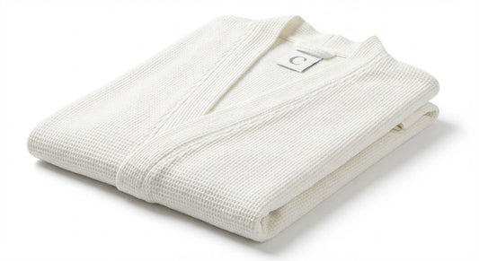 Folded white bathrobe with a brand logo on a white background